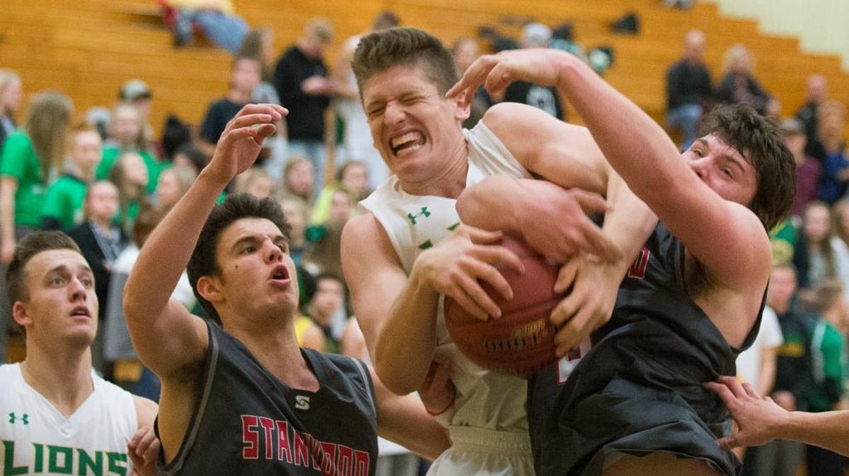 Lynden’s Trey Labounty, center, fights for a rebound with Stanwood’s Mitch Jones, right, and Matt Vail, left, on Tuesday, Nov. 28, at Lynden High School. Stanwood defeated Lynden 63-58.
