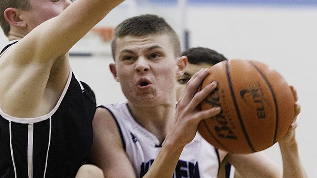 Mount Baker’s TJ Bass, left, attempts to block Lynden Christian’s Jake Poag during the third quarter of the 2015 Class 1A Northwest District Tournament semifinal at Lynden Christian.