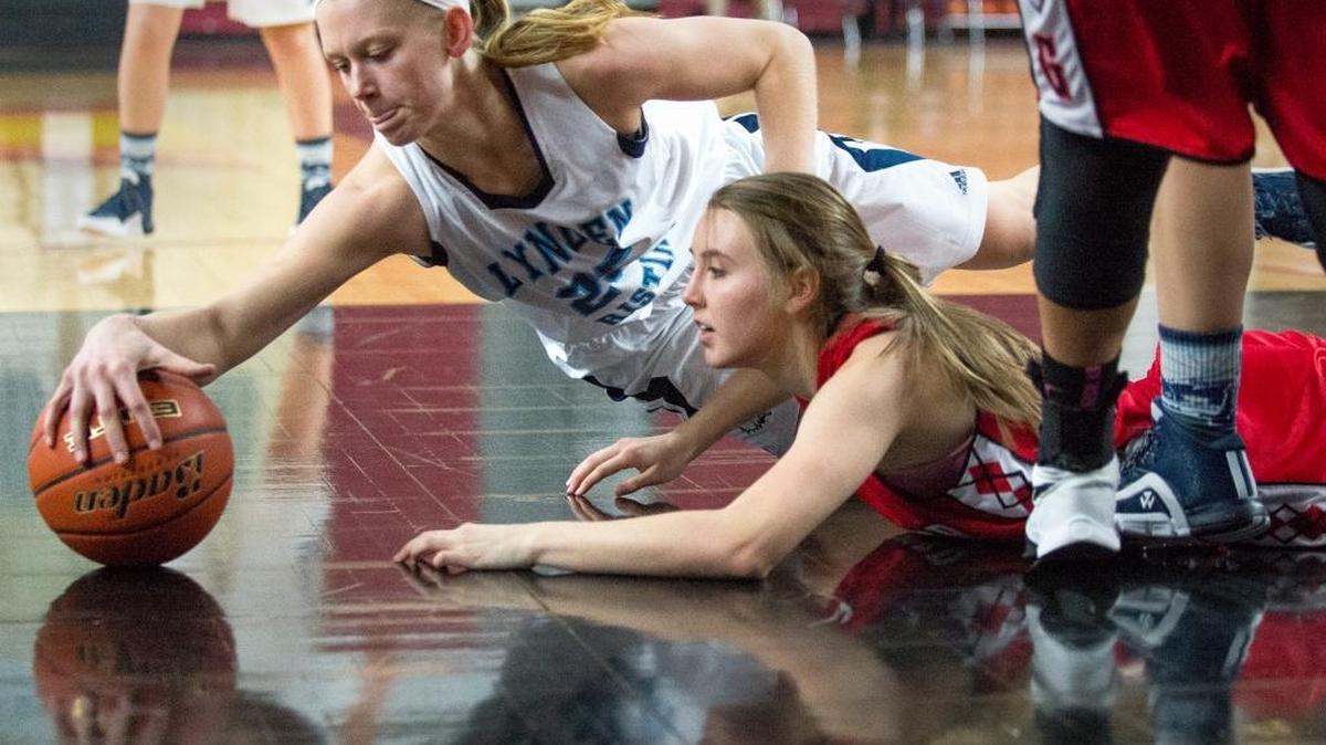 Lynden Christian's Sam Van Loo dives for a loose ball over Granger's Lindsey Carpenter in a girls' 1A state semifinal game on Friday, March 4, at the Yakima Valley SunDome.