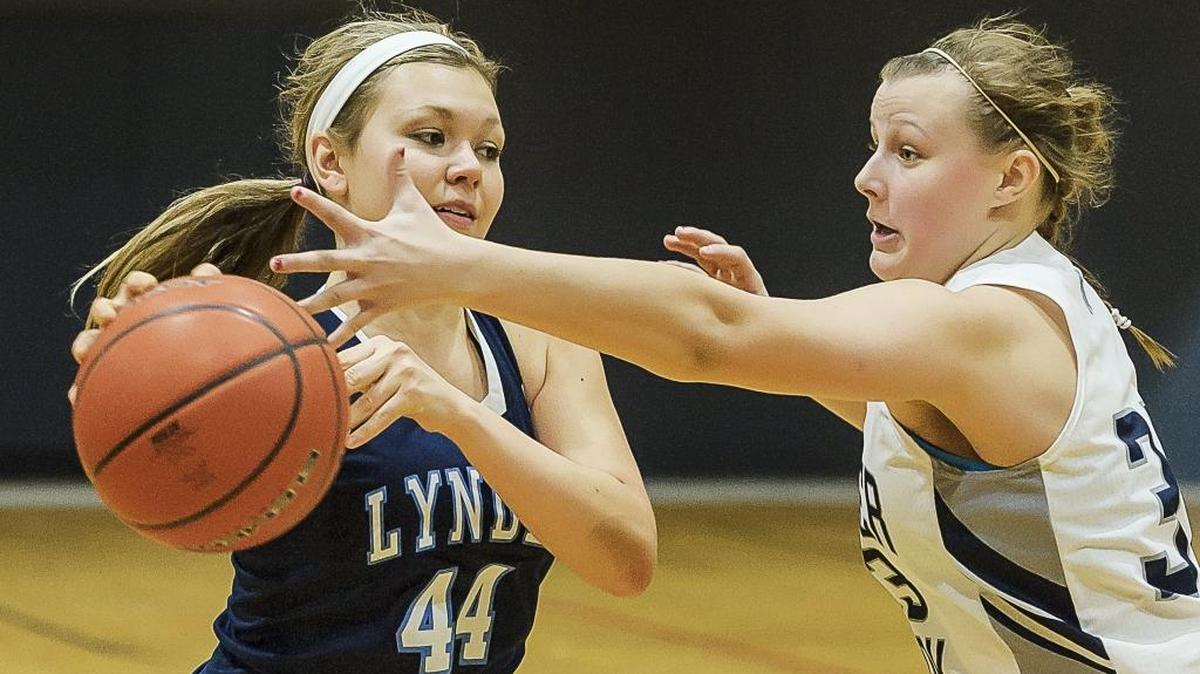 Lynden Christian’s Emmalee Baily (44) passes to an open teammate as Glacier Peak’s Abbie Jouzapaitas (33) attempts to cover in the fourth quarter during the Cloud 9 Sports Christmas Classic on Wednesday, Dec. 30, 2015, at Lynden Christian.