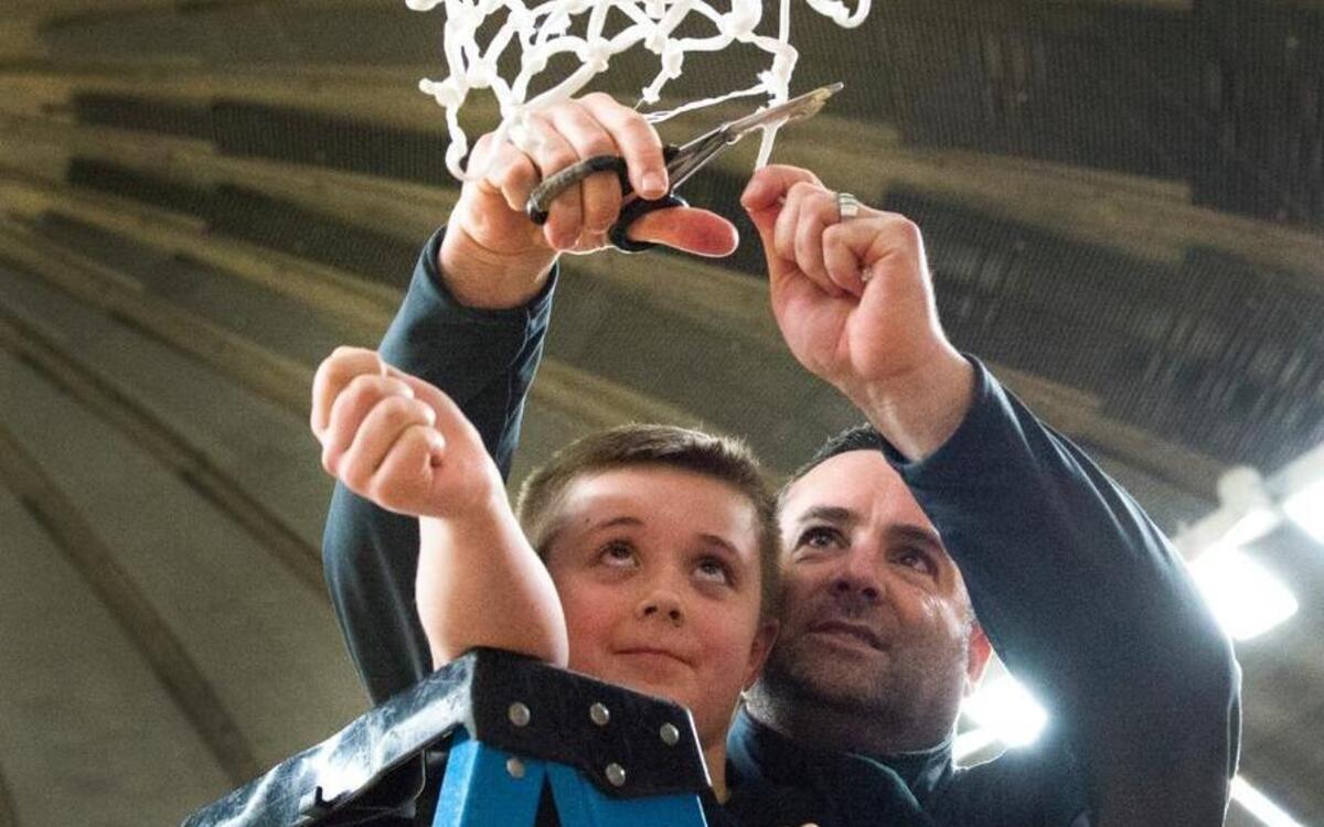 Lynden girls’ basketball coach Rob Adams cuts down the net as his son Spencer looks on after Lynden defeated Burlington-Edison 44-36 in the Class 2A state championship game March 4 at the Yakima Valley SunDome. Adams was named girls’ basketball coach of the year in Washington.