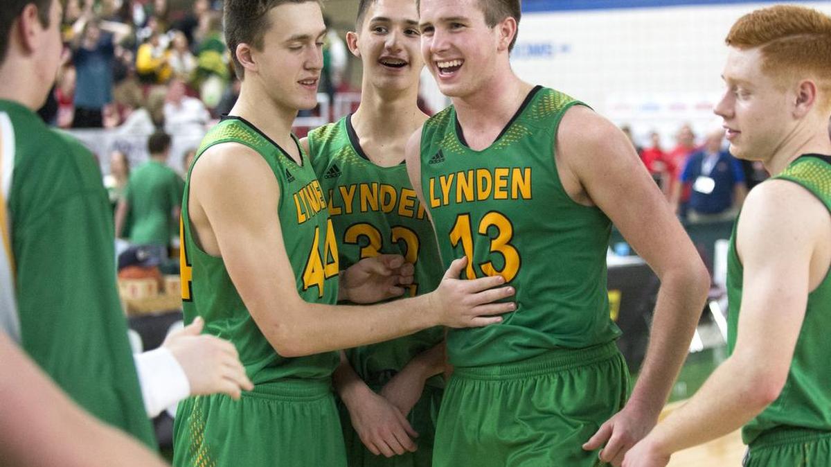 Lynden players celebrate winning the third-place game of the 2A boys' state basketball tournament at the Yakima Valley SunDome.