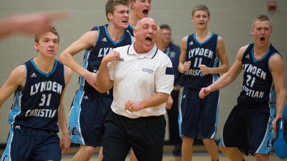 Lynden Christian head coach Roger DeBoer, center, celebrates with his players after a 86-84 victory over Squalicum in overtime on Thursday, Dec. 17, at Squalicum High School in Bellingham