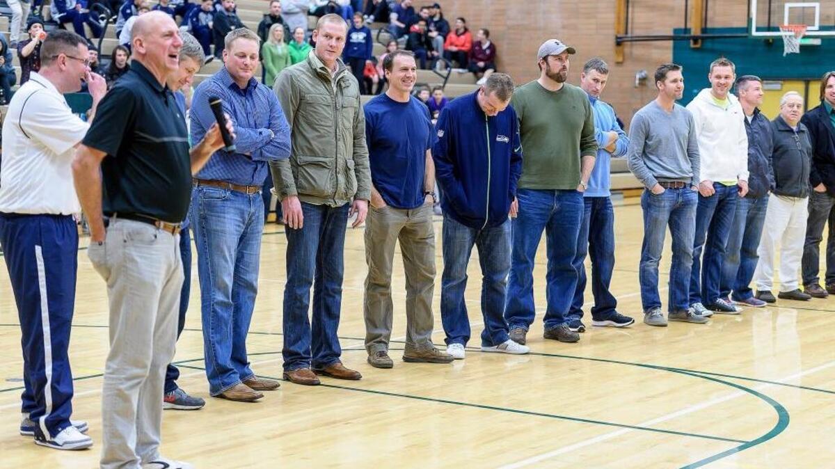 Former Sehome basketball head coach Pat Fitterer, left, says a few words to the crowd during halftime as Sehome hosts Arlington on Monday Dec. 21, at Sehome High School. The 1996 Mariners boys team was honored during halftime for their undefeated season winning the state title and going 30-0.