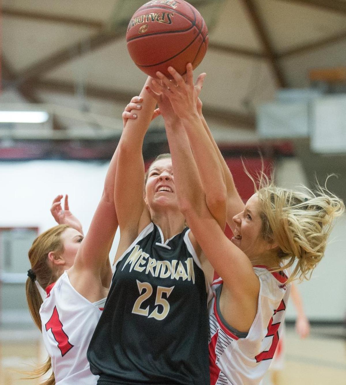 Meridian’s Lindsey Moore, center, is fouled while grabbing a rebound between Mount Baker’s Haylee Malone, left, and Portia Allred, right, on Thursday, Nov. 30, at Mount Baker High School in Deming. Meridian defeated Mount Baker 62-56.