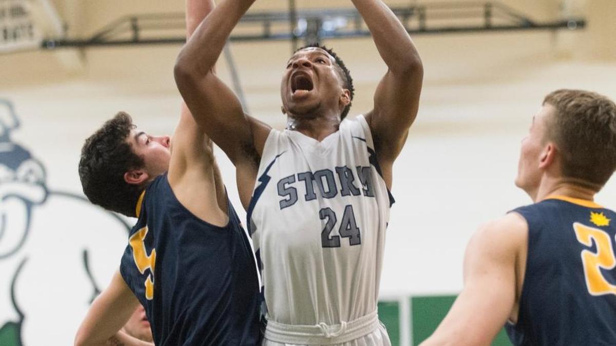 Squalicum’s Damek Mitchell, center, is fouled as he shoots by Bellevue’s Spencer Birkeland during a 66-63 loss in an elimination game of the 3A state basketball tournament on Friday at Mount Vernon High School.