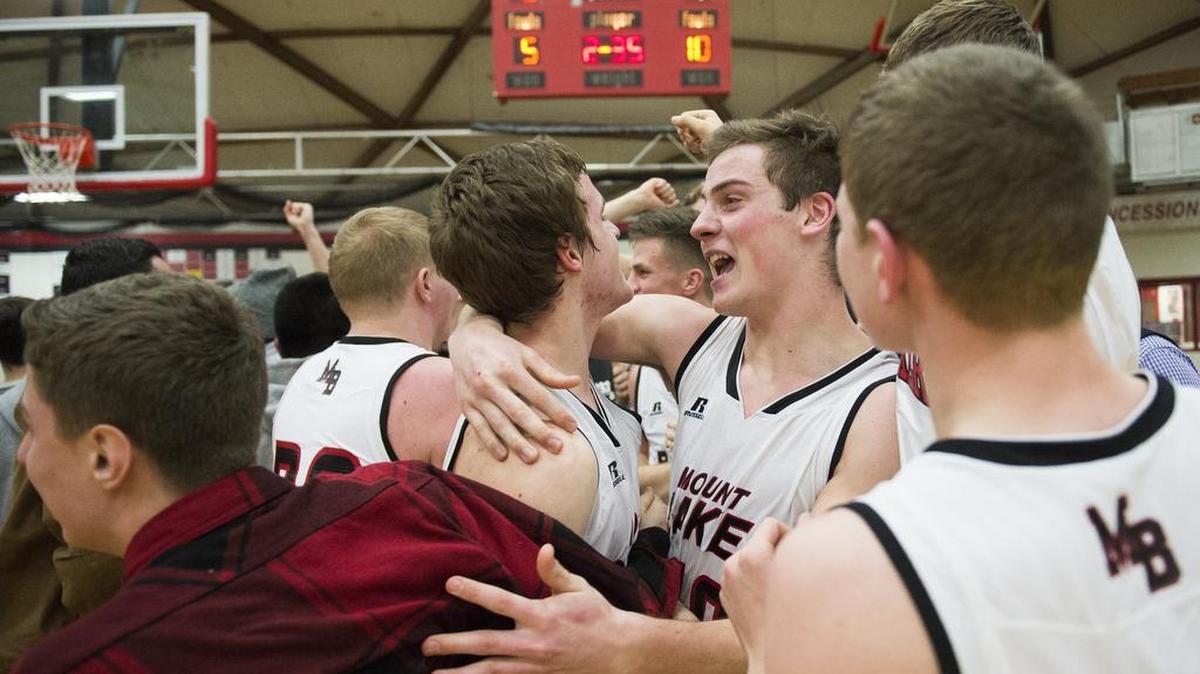 Mount Baker's Thomas Barbo, center left, is hugged by Jed Schleimer as other teammates and students celebrate on the court after Barbo made a buzzer-beater layup to defeat Lynden 53-51 on Tuesday, Jan. 31, in Deming.