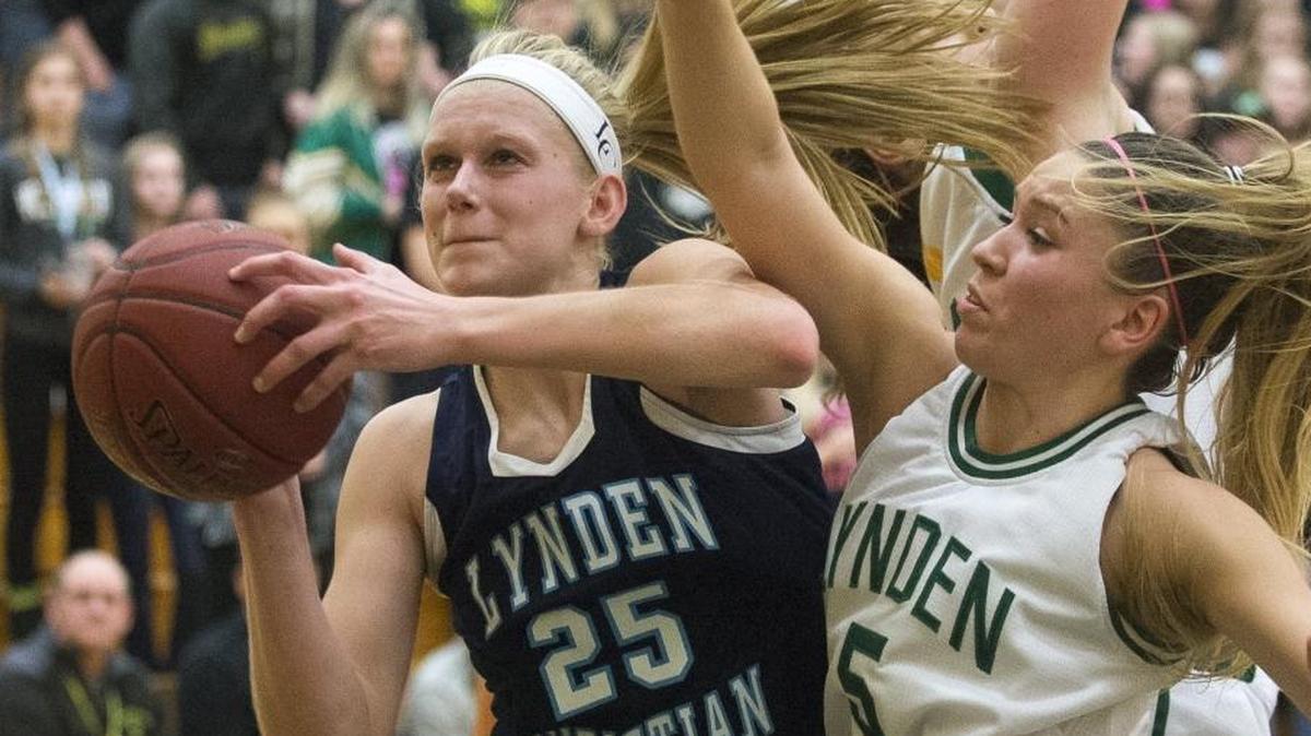 Lynden Christian’s Sam VanLoo scores after getting an offensive rebound as Lynden's Jasmyne Neria, right, plays defense in a Jan. 19 game. VanLoo signed her letter of intent to play for Ken Crawford at Northwest University in Kirkland next year.