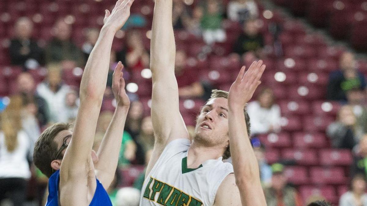 Lynden’s Andrew Kivlighn shoots and scores between Olympic’s Jr Nelson, right, and Tyler Yost, left, in the third-place game of the Class 2A state basketball tournament on Saturday, March 4, at the Yakima Valley SunDome in Yakima. Lynden defeated Olympic, 69-49.