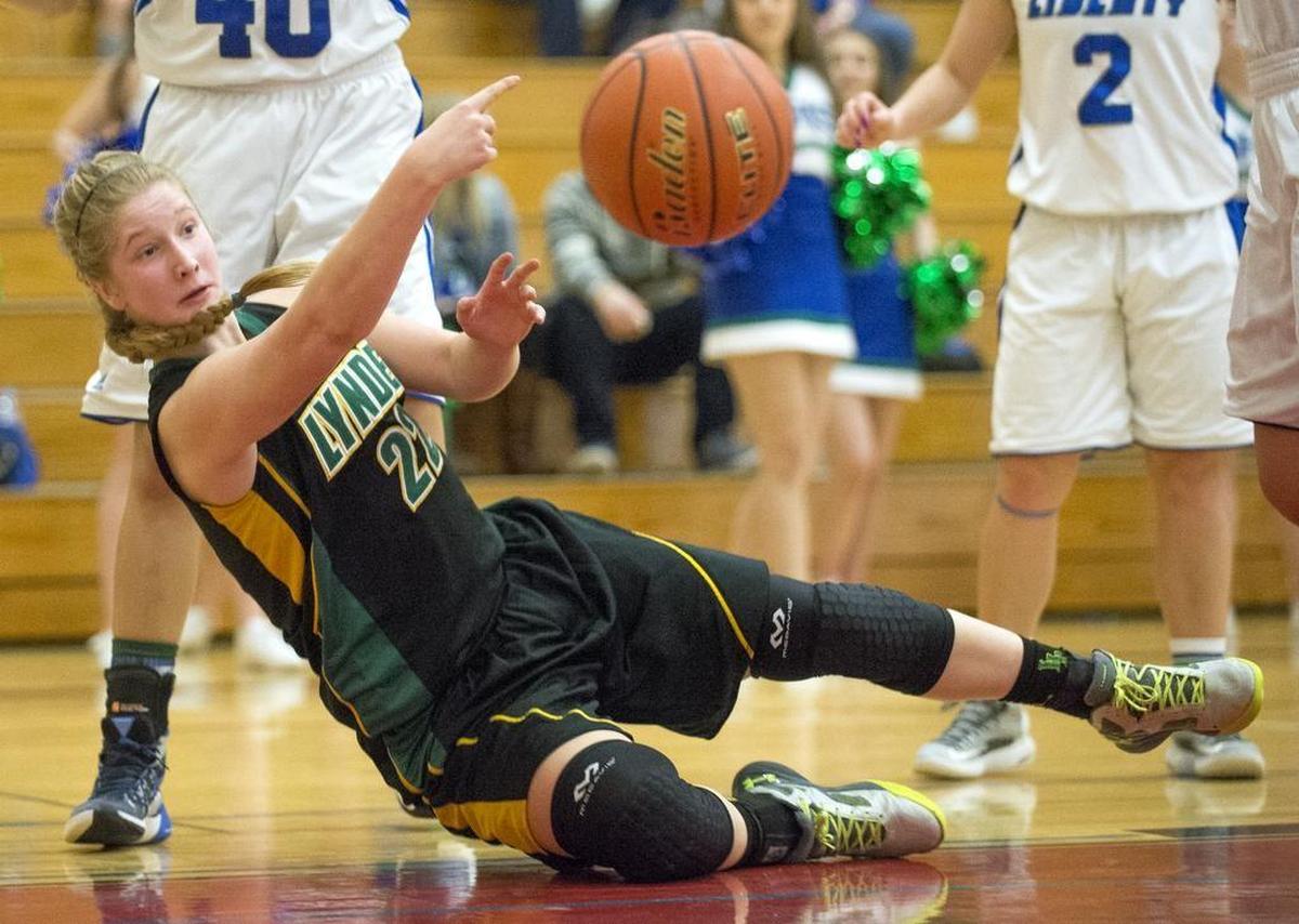 Lynden's Elisa Kooiman passes the ball to a teammate as she falls out of bounds during a 67-39 victory over Liberty on Saturday, Feb. 27, at Renton High School.