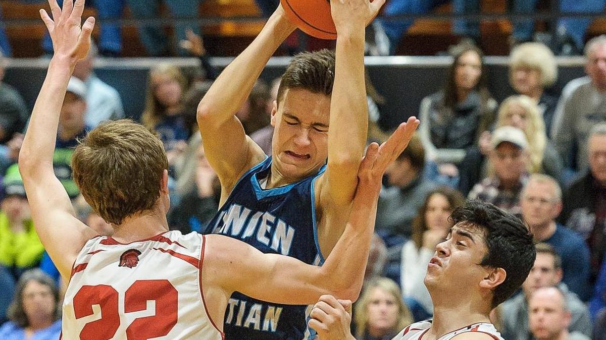 Lynden Christian's Grant Rubbert (35) grabs a rebound against Granger's Jake Slade (22), left, and Jay Ramirez (1) in the Cloud 9 Sports Christmas Classic on Tuesday, Dec. 29, at Lynden Christian High School. An earlier version misidentified Rubbert.
