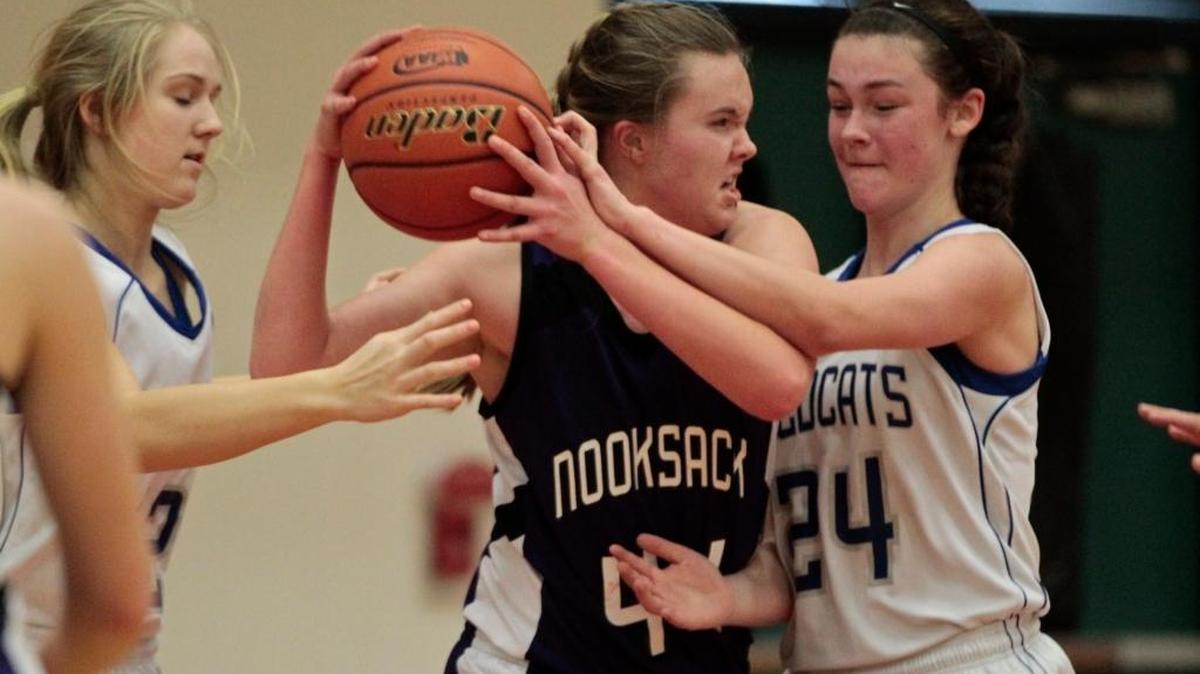 Nooksack Valley’s Brianna Turner, left, and La Center’s Taylor Stephens, right, during playoff game on Saturday Feb. 27 at Battle Ground High School in Battle Ground.