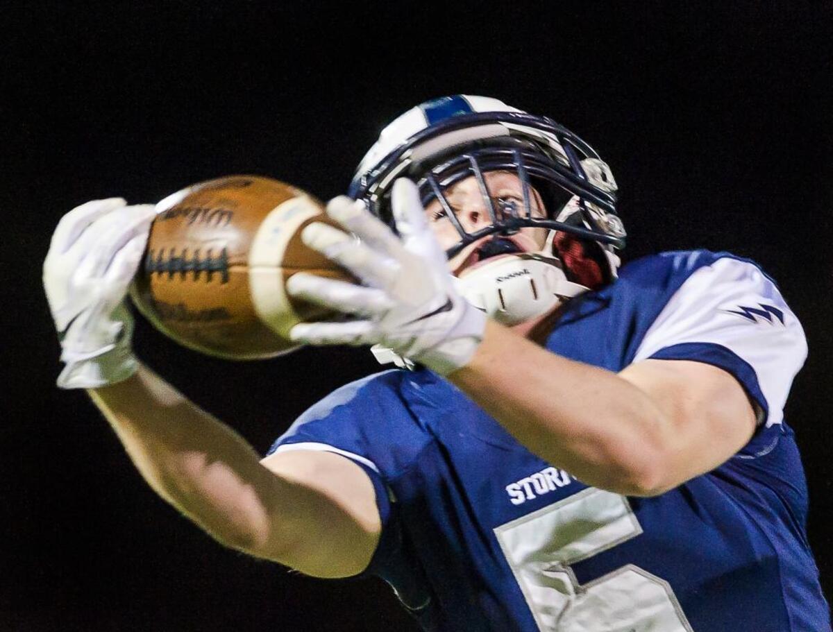 Squalicum wide receiver Ben Peterson (5) stretches to catch a 20-yard pass from quarterback Garrett Sorenson for a first down late in the second quarter on Saturday evening, Oct. 10, at Civic Stadium in Bellingham.