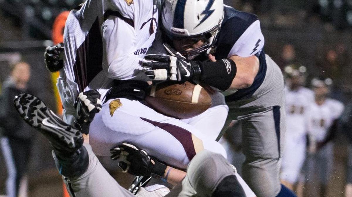 Squalicum's Jacob Burgoon, bottom, and Brian Pullman, right, sack Lakewood's Austin Lane during a 2A Northwest District playoff football game on Saturday, Nov. 7, at Civic Stadium in Bellingham.