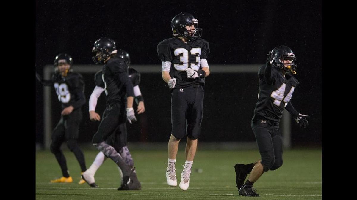 Meridian’s Dylan Hickok, center, and Bryson Hickok, right, celebrate among teammates after Dylan forced a fumble during a 34-14 victory over La Center Nov. 25 at Civic Stadium in Bellingham to advance to Saturday’s 1A state title game.