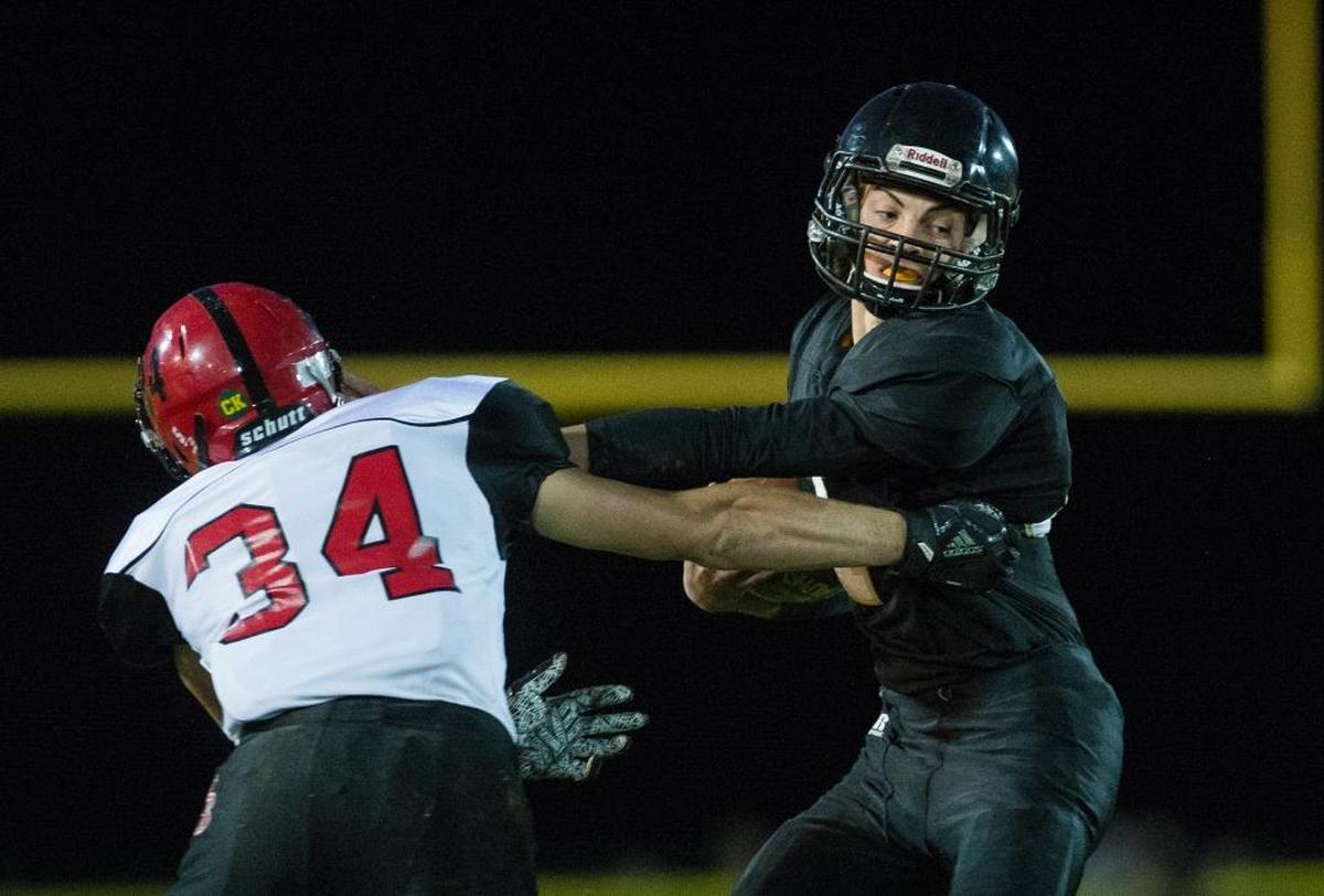Meridian’s Dawson Logan, right, looks to break a tackle by Mount Baker’s Sam Barrett Oct. 6.