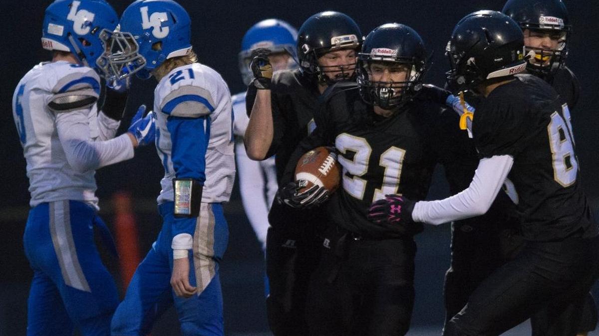 Meridian’s Lukas Hemenway, center, celebrates with teammates after scoring a touchdown against La Center on Saturday, Nov. 25, at Civic Stadium in Bellingham.