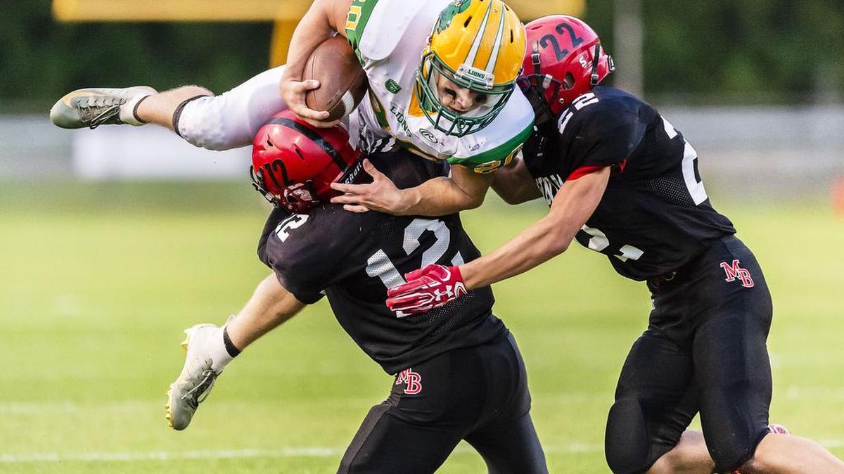 Lynden running back Steven DiLorenzo (20) is upended at the line of scrimmage by Mount Baker defensivemen Kaleb Bass (12) and Mark Tikhonov (22) during the second quarter on Friday evening Aug. 31, 2018, at Mount Baker High School in Deming, Wash. Lynden defeated Mount Baker 35-34 during opening night of the regular season.