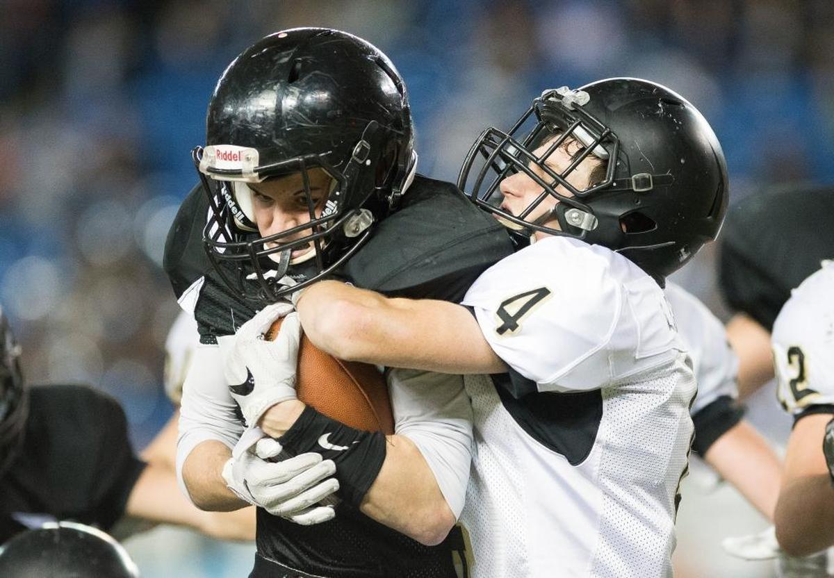 Meridian’s Dylan Hickok fights through a tackle by Royal’s Logan Gilbert in the 1A state championship game Saturday, Nov. 2, at the Tacoma Dome.