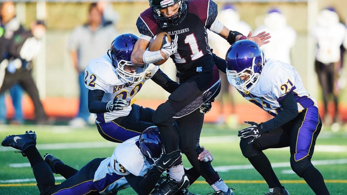 Lummi’s Free Borsey (11) escapes the grasp of Quilcene's Olin Reynolds (13), bottom, Jarod Smith (22), left, and Andy Johnston (21) during the third quarter in the 1B state quarterfinals on Saturday, Nov. 21, at Lummi Nation School.