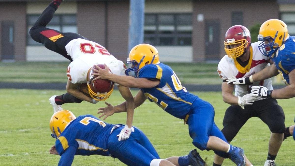 Ferndale’s Jake Leavitt and Taylor Bellefeuille knock Kamiakin's Jethro Questad backward on Sept. 5.