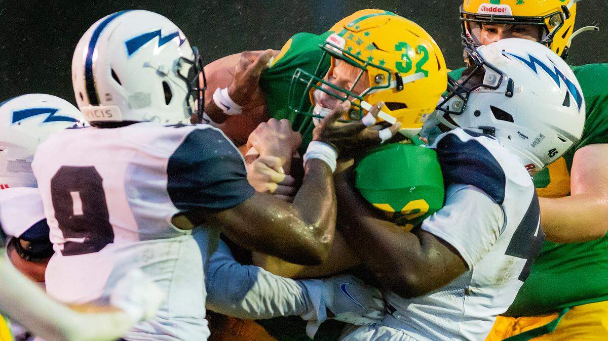 Lynden running back Lane Heeringa (32) is tackled by a gang of Squalicum defensivemen as he attempt to cross the line of scrimmage during the first quarter at Lynden High School on Friday evening, Sept. 17, in Lynden. Lynden defeated Squalicum 15 to 12.