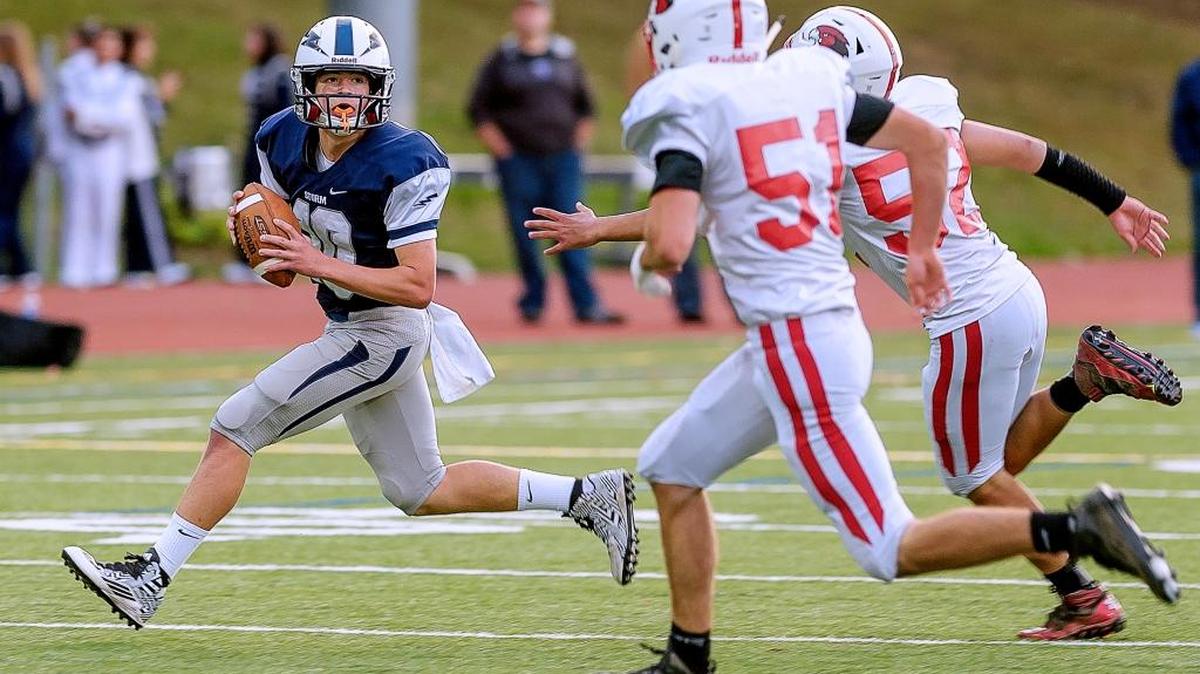 
Squalicum quarterback Garrett Sorenson (10) looks for an open man while evading Bellingham linebackers during the second quarter Friday, Sept. 4, at Civic Stadium.
