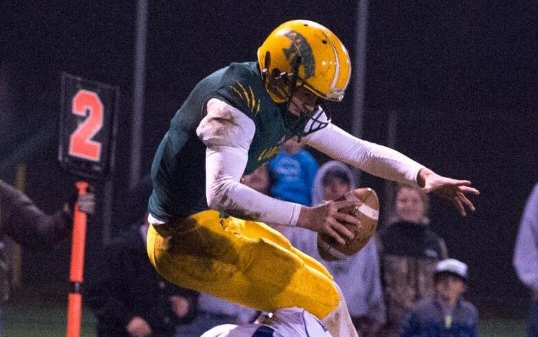 Lynden's Sterling Somers hurdles Sedro-Woolley's Josh Gaethle for a touchdown during a 32-29 loss in overtime on Friday, Oct. 23, in Lynden.