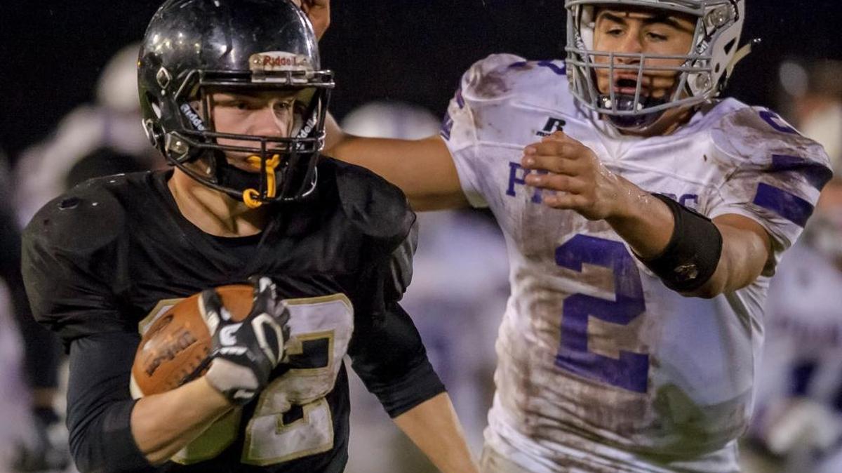 Nooksack Valley’s Casey Bauman reaches for Meridian’s Tony Schleimer as he runs down the sideline Oct. 21, 2016. The two teams will meet Friday at Meridian High.