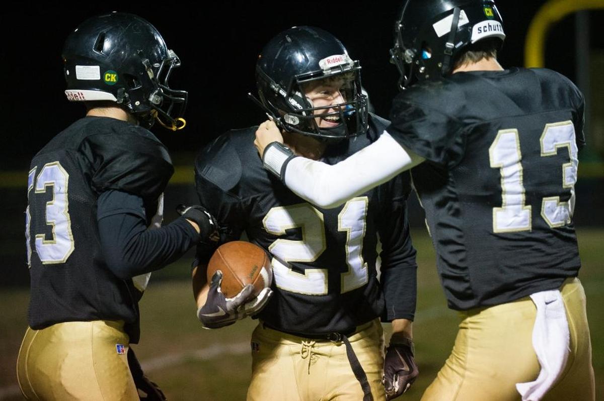 Meridian’s Lukas Hemenway, center, celebrates with teammates Baker Otter, left, and Simon Burkett, right, after scoring a touchdown during a 50-36 victory over Nooksack Valley Sept. 29.