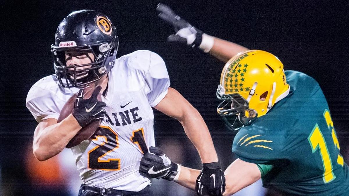 Blaine’s Riley Fritsch (21) slips through the hands of Lynden’s Jacob Kettels (73) at the line of scrimmage during the second quarter on Friday, Oct. 7, at Lynden High School.