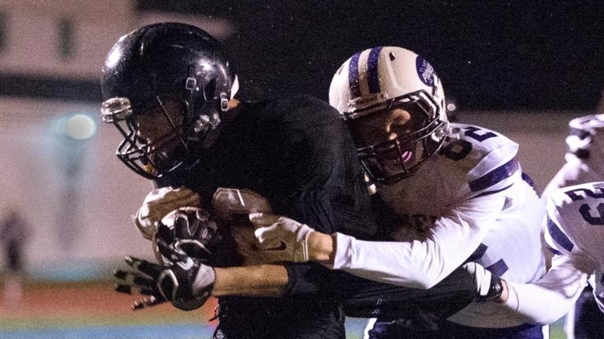 Meridian’s Tony Schleimer drags Nooksack Valley’s Jordan Veening, center, and Tre Silva, right, into the end zone for the game-winning touchdown on Tuesday, Nov. 1, in Sedro-Woolley.