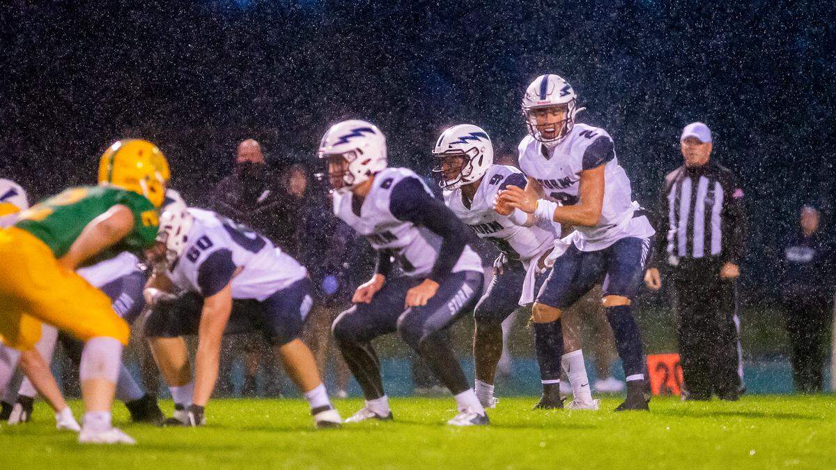 Heavy rains soak the Squalicum Storm offensive line as quarterback Leyton Smithson (2) calls the play during the second quarter against the Lynden Lions at Lynden High School on Sept. 17, 2021, in Lynden, Wash. Lynden defeated Squalicum 15 to 12.