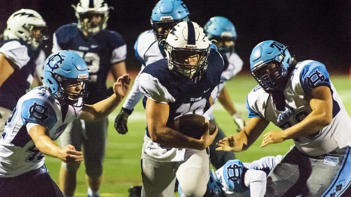 Squalicum quarterback Spencer Lloyd breaks through Gig Harbor’s CP Loughren (42), and Nick Belarde (70) to score a touchdown during the first quarter Friday at Civic Field. The game ended too late to get final results before deadline.