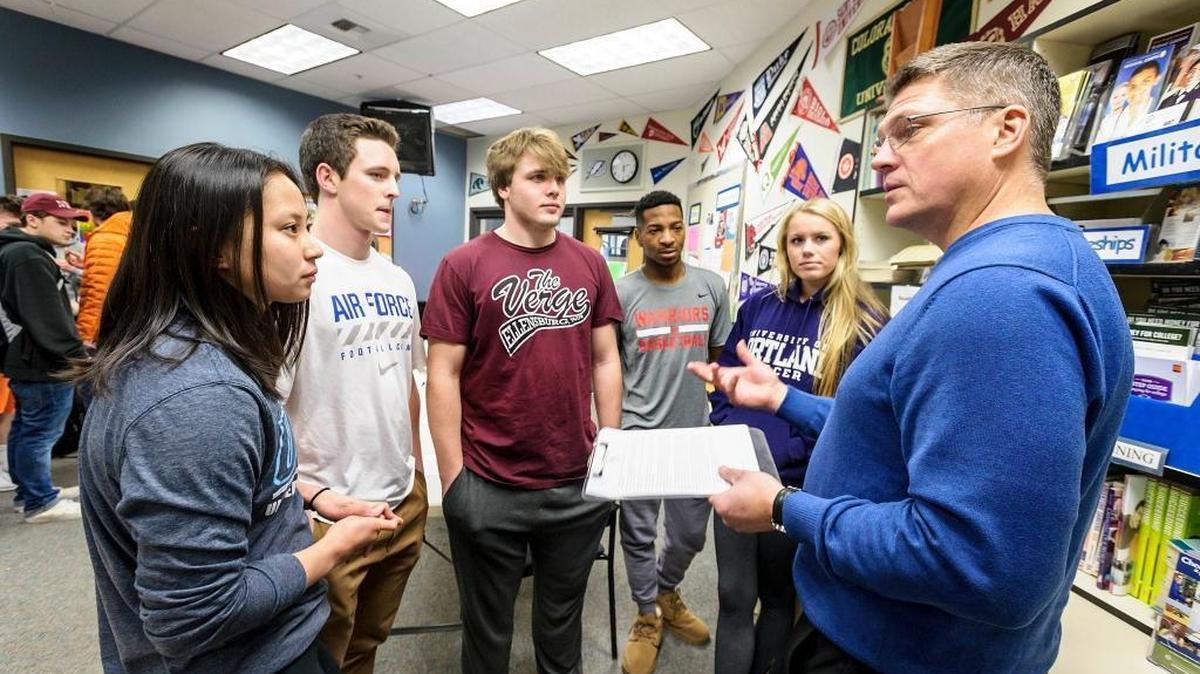 Athletic director Patrick Brown, left, gives instructions to seniors (l to r) Sydney Wong, Ben Peterson, Jack Wendling, Damek Mitchell, and Kendra Steele during signing day at Squalicum High School on Wednesday Feb. 1, 2017, in Bellingham, Wash. Brown said that in his 8 years as AD, he has not seen this many Squalicum students sign letters of intent.