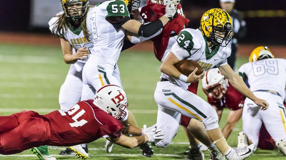 Bellingham defensive back Jacob Hallock, left, dives to catch Sehome running back Dylan Roberts as Roberts runs for a first down during the second quarter in their 2A first-round Northwest District elimination game on Friday evening, Oct. 26, 2018, at Civic Field in Bellingham, Wash. Sehome defeated Bellingham 28-21 and advances to face Archbishop Murphy in the next round. (Paul Conrad for the Bellingham Herald)