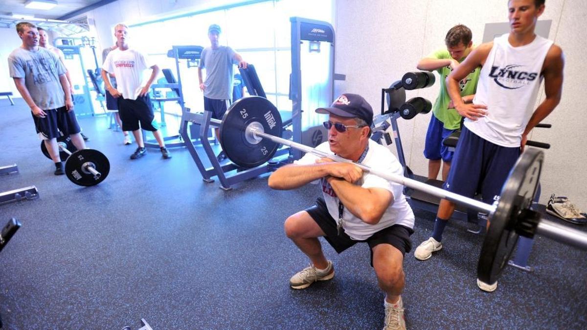 Players watch as coach Galen Kaemingk shows them proper form for squat lifts before they lift weights in the new weight room on the first day of football practice at Lynden Christian in Aug. 2011. After five years, Kaemingk has stepped down as coach of the Lyncs.