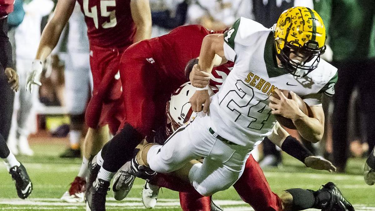Sehome running back Dylan Roberts dives for extra yardage as Bellingham’s Jackson Taylor and Isiah Harrington take him down after a short gain in the first quarter on Friday evening, Oct. 19, 2018, at Civic Stadium in Bellingham, Wash. Sehome defeated Bellingham 54-27.