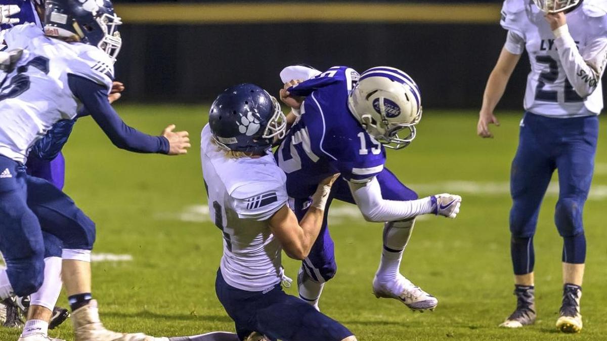 Lynden Christian’s George de Jong takes down Nooksack Valley’s Michael O’Bryan after a short gain Oct. 28 in Everson.