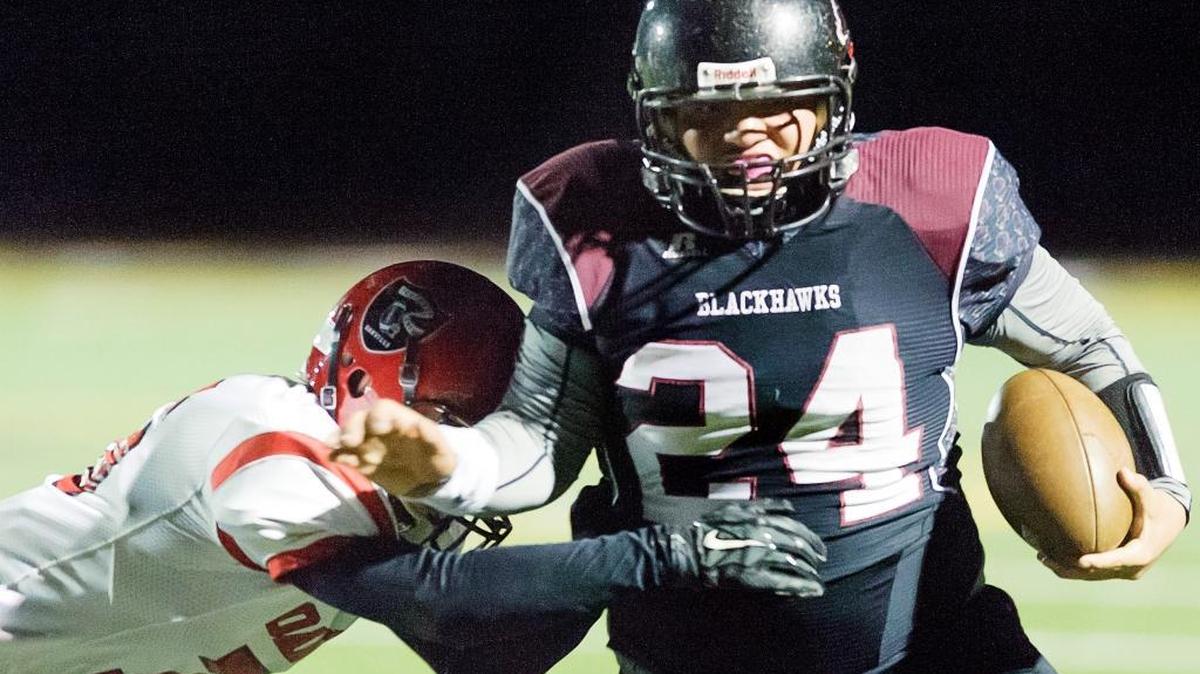 Oakville's Anthony Eichelberger, left, attempts to tackle Lummi's Hank Hoskins (24), as Hoskins runs for a touchdown during the first quarter on Friday, Nov. 6, at Lummi. The Blackhawks won 56-8.