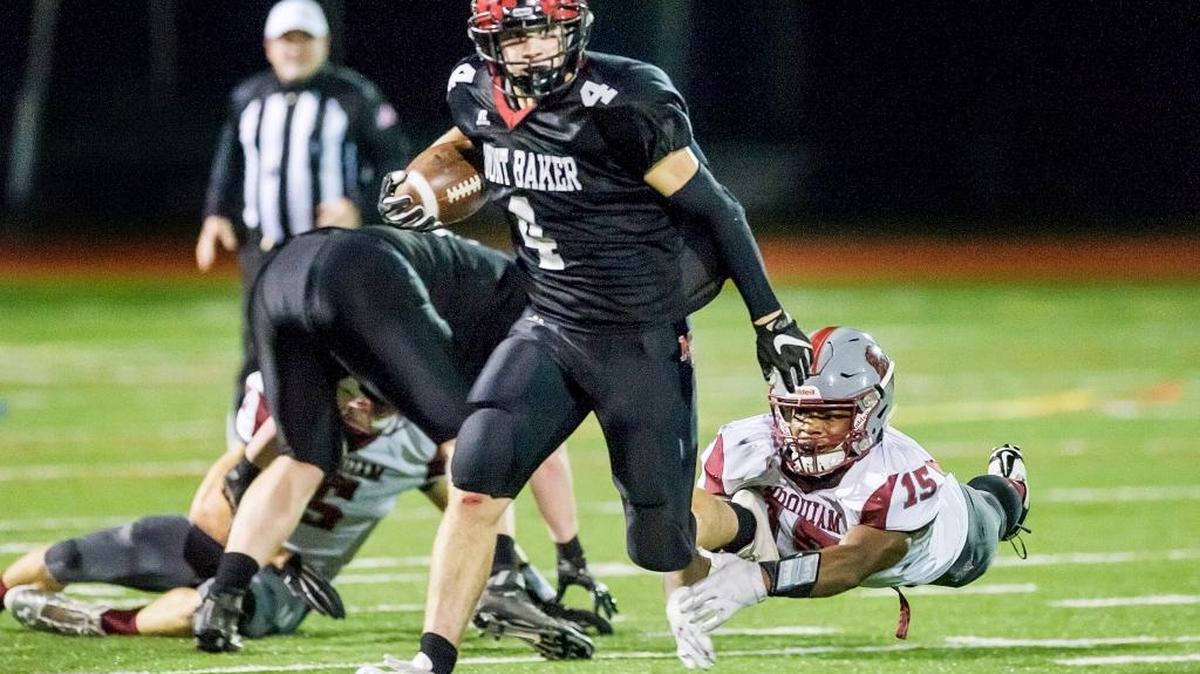 Hoquiam’s Artimus Johnson dives to stop Mount Baker’s Jed Schleimer as he breaks the line of scrimmage during the first quarter of the Class 1A state playoff game Saturday at Civic Stadium.