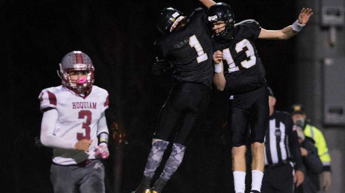 Meridian's Dawson Logan, center, and Simon Burkett, right, celebrate a touchdown during a 1A state playoff victory over Hoquiam Saturday, Nov. 11, at Civic Stadium.
