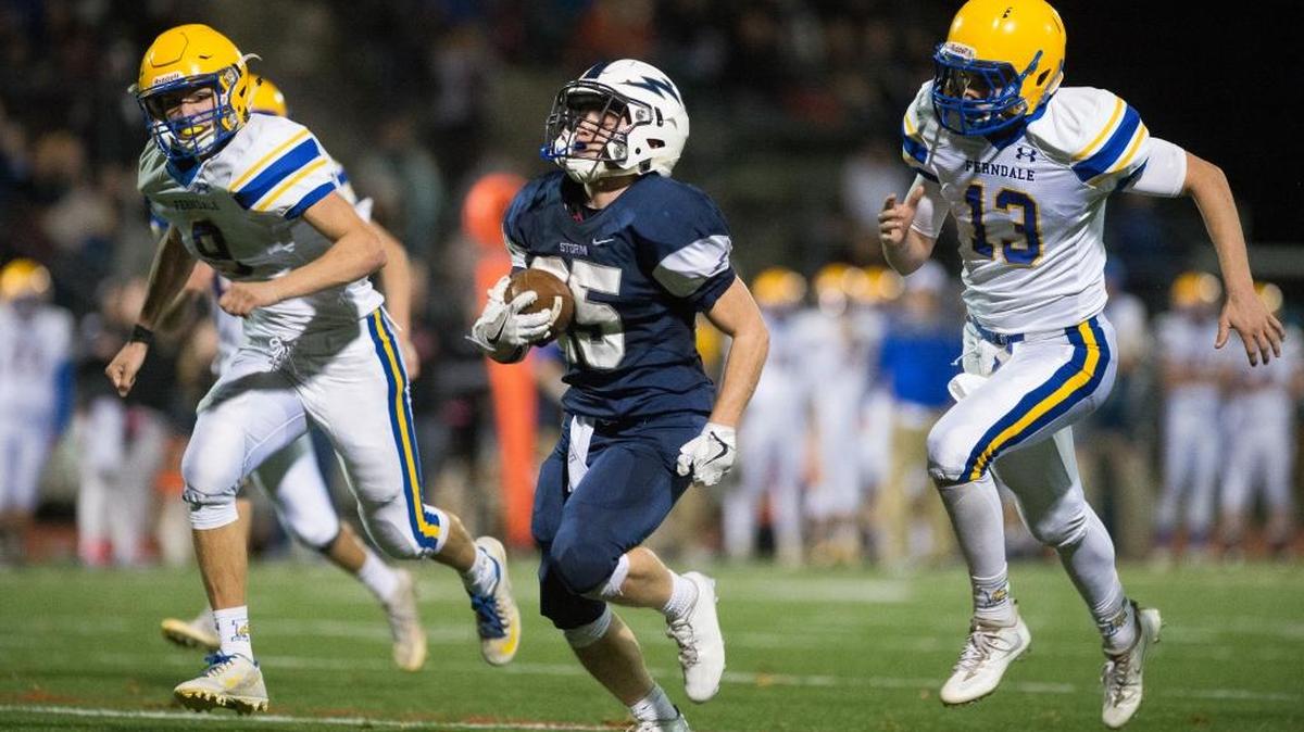Squalicum’s Triston Smith, center, runs past Ferndale’s Justice Powell, left, and James Hinson for a touchdown Saturday at Civic Stadium.