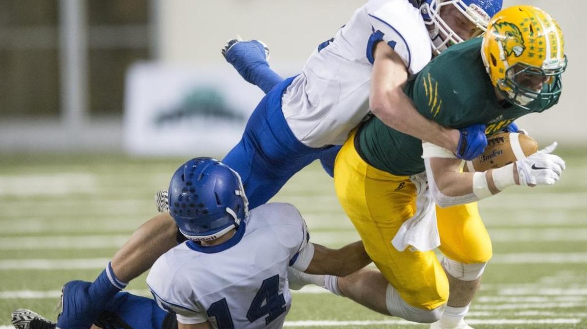 
Lynden's Scooter Hastings is knocked out of bounds by Sedro-Woolley's Anthony Cann and Quinten Dickman-Roppel in the 2A state championship game on Saturday, Dec. 6, at the Tacoma Dome. The Cubs and Lions both enter 2015 ranked in the top three of the Class 2A poll. 
