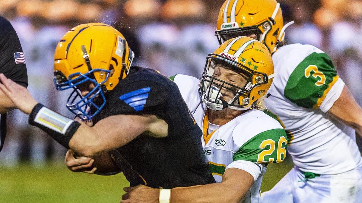 Ferndale running back Ryan Pelton, left, gets wrapped up at the line of scrimmage by Lynden linebacker Taivin VanDalen (26) before gaining short yardage Sept. 13, 2019, at Ferndale High School. Lynden defeated Ferndale 33-121.
