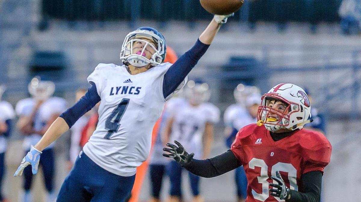 Lynden Christian’s Michael Lancaster reaches for an overthrown pass as Bellingham’s Nich Smith moves in during the second quarter on Friday, Sept. 2, at Civic Field in Bellingham, Wash.