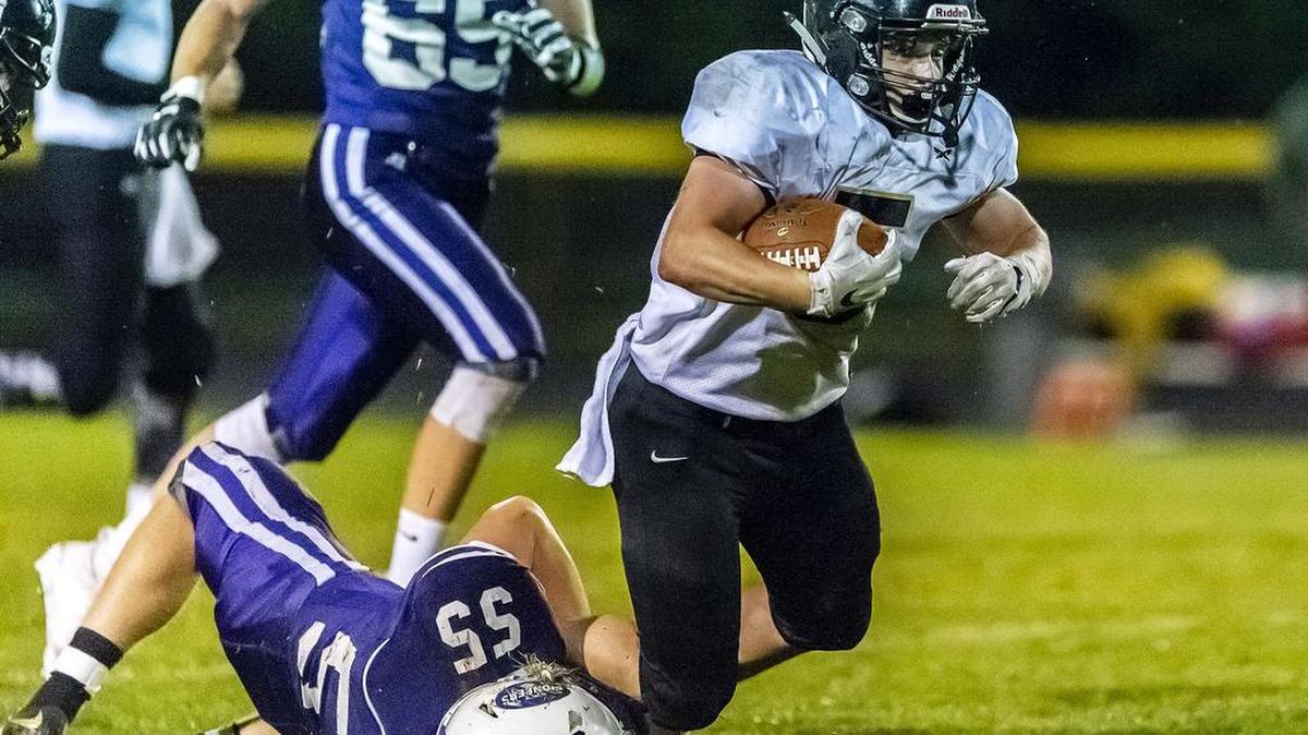Meridian running back Cole Roberts (5) attempts to break free from the grip of Nooksack Valley linebacker Dane Winter (55) after a short gain during the second quarter on Friday evening, Sept. 21, 2018, at Nooksack Valley High School in Everson, Wash. Meridian defeated Nooksack Valley 21-14.