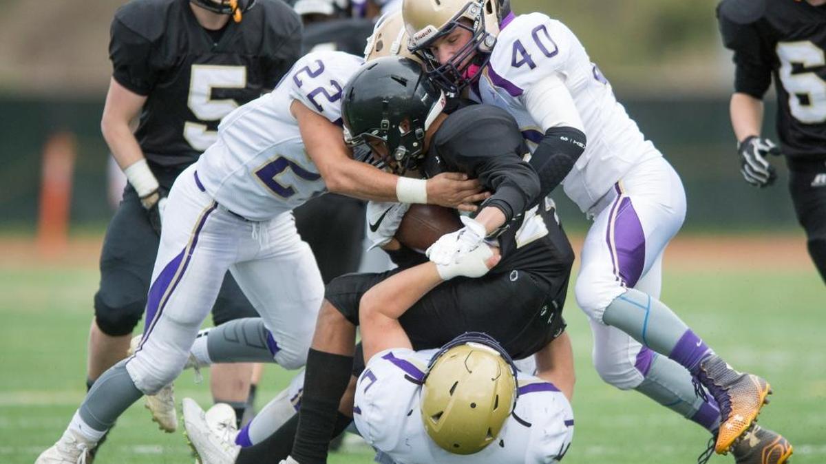 Meridian’s Harlen Stuit is tackled by Connell’s Branden Chavez, left, Jekoby Tuttle, right, and Brian Hawkins, bottom, on Saturday, Nov. 19, at Civic Stadium in Bellingham.