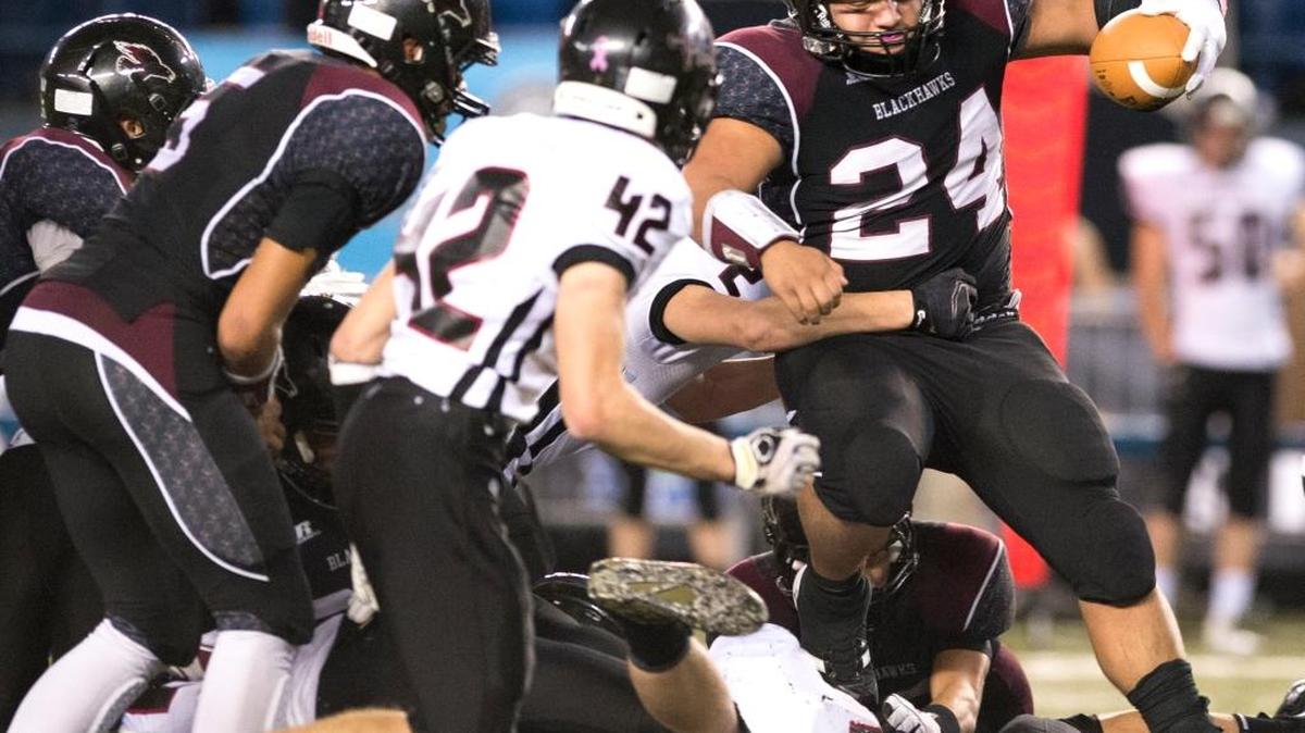 Lummi’s Hank Hoskins hurdles diving Almira-Coulee-Hartline defenders during the Class 1B State Championship on Friday, Dec. 4, at the Tacoma Dome.