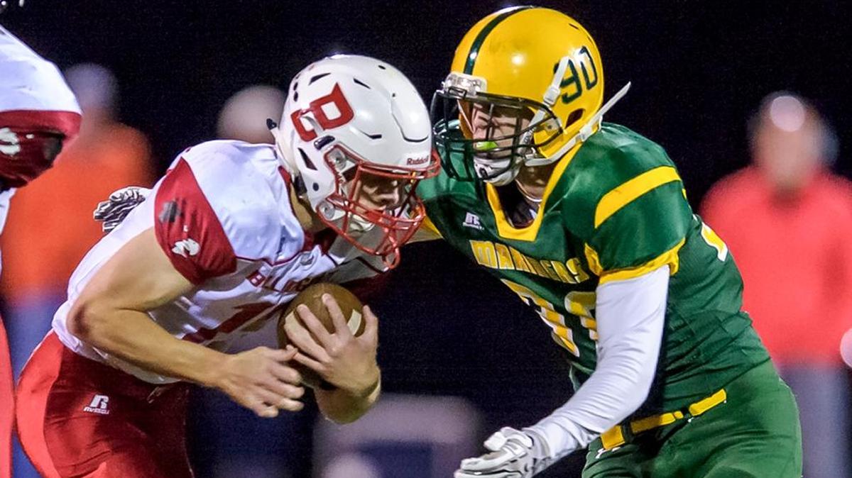 Bellingham running back Connor Wallace, left, attempts to avoid a Sehome tackler Oct. 6 at Civic Stadium.